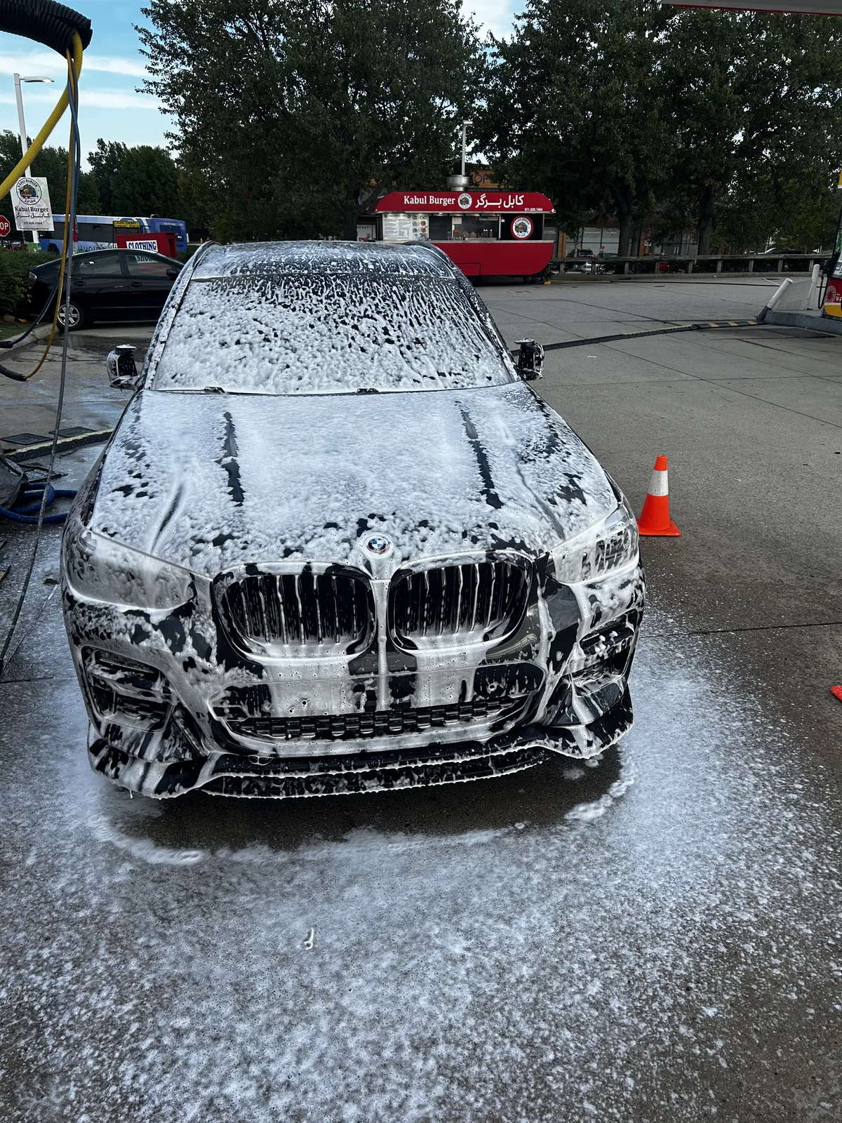 BMW sedan covered in foam during an exterior wash